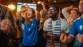 Group of Multiethnic Soccer Fans with Colored Faces Watching a Live Football Match in a Sports Bar Royalty Free Stock Photo