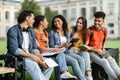 Group Of Multiethnic Students Chatting And Laughing While Sitting Together Outdoors Royalty Free Stock Photo