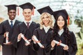 group of multiethnic students with diplomas in graduation hats standing Royalty Free Stock Photo