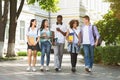 Group of multiethnic students walking together outdoors in college campus Royalty Free Stock Photo