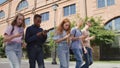 Group of multinational college students obsessed with smartphones walking outdoors Royalty Free Stock Photo