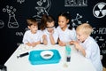 Group of multiracial diverse kids carrying out a science experiment in lab Royalty Free Stock Photo