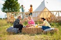 Group of multiracial friends meeting together at the campsite they have a picnic time together discussing drinking enjoy