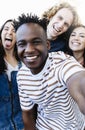 Group of multiracial happy best friends taking selfie photo with smartphone Royalty Free Stock Photo