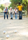 A group of multiracial mature adult people playing patanque game outdoors in a park Royalty Free Stock Photo