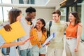 Group of multiracial students talking and smiling after class at university campus. Diverse tenagers laughing and having Royalty Free Stock Photo