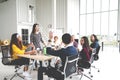 Group of multiracial young creative team talking, laughing and brainstorming in meeting at modern office concept. Female standing Royalty Free Stock Photo