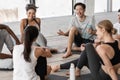 Group of multiracial young people communicating before yoga class in studio Royalty Free Stock Photo