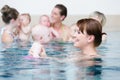 Group of mothers with children at baby swimming lesson