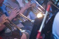 A group of musicians are playing on shiny trumpets. Musical symphony or jazz concert