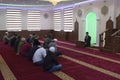 Group of Muslim men kneeling and listening to mullah preaching in a mosque. Kyiv, Ukraine