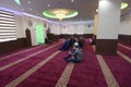 Group of Muslim men kneeling and listening to mullah preaching in a mosque. Kyiv, Ukraine