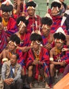 A group of Naga tribesmen siting wearing their traditional attire