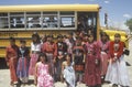 Group of Native American girls in costume standing in front of school bus in Mexican Hat, southern UT