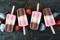 Group of neapolitan popsicles in a row on a dark slate background Royalty Free Stock Photo