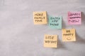 Group of New year Resolution Notes on pink, yellow, orange and green on wall written with message of more family time, lose