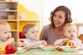 Group of nursery babies eating healthy food lunch break together