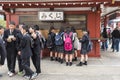 Group o schoolboys and girls buying omikuji paper fortune Sensoji Tokyo Royalty Free Stock Photo