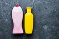 A group of objects for the care of their hygiene. A botle of shower products on a black concrete surface. Shampoo, body gel.