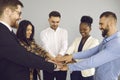 Group of happy business people demonstrating teamwork and putting their hands together Royalty Free Stock Photo