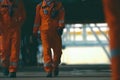 group of oil rig workers in orange overalls going to a work shif Royalty Free Stock Photo