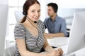 Group of operators at work. Call center. Focus on beautiful woman receptionist in headset at customer service. Business Royalty Free Stock Photo