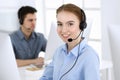 Group of operators at work. Call center. Focus on beautiful woman receptionist in headset at customer service. Business