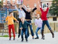 Group of ordinary kids in high spirits jumping