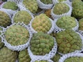 Group of organic sugar apples in foam fruit nets at a fruit market