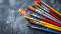 A group of paintbrushes with different colors on a gray background, AI