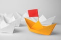 Group of paper boats following orange one on white background, closeup. Leadership concept Royalty Free Stock Photo