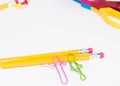 Two paper clips talking while lying on a white floor and on a pencil. Miniature school life and back to school concept with copy s