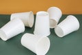 Group of paper cups laying on green table. Cup stacking fail attemp Royalty Free Stock Photo