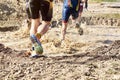 Group of participants in an obstacle course race running across a pool of water. Spartan race. Concept of effort