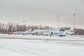 Group of passenger airplanes with attached ladder in winter airport