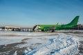 Group of passengers leaving airplane and getting on bus after landing in winter airport in sunny day Royalty Free Stock Photo