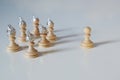 Group of pawn chess pieces with tinfoil hats against imagined heteronomy stand towards a piece without hat, conspiracy theory and