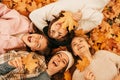 Group of people. Autumn portrait. Happy young women students playing with leaves, smiling while lying on ground in park Royalty Free Stock Photo