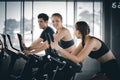 Attractive woman biking in the gym, exercising legs doing cardio workout cycling bikes. Fitness club with training exercise bikes Royalty Free Stock Photo