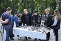 Group of people, buyers, and blacksmith left standing in front of a table with forgings and discussing them Royalty Free Stock Photo