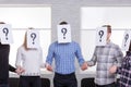 A group of people with closed faces sheets with a question mark holding hands Royalty Free Stock Photo