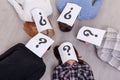 A group of people with closed faces sheets with a question mark lie on the floor of five people close-up