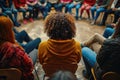 Group of people in a community sitting in a circle and chatting in a crowd in a meeting room without distinguishable faces and Royalty Free Stock Photo