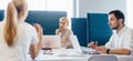 Group of people confer at work sitting at desk