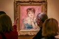 A group of people are considering the picture of Renoir `Portrait of the Actress Jeanne Samary` in the art gallery of the Pushkin