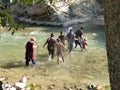 Group of people crossing a river on foot in the Fergana Valley in Uzbekistan. Royalty Free Stock Photo