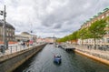 A group of people cruise a river canal in the urban center of Copenhagen, Denmark