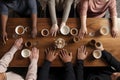 Group of people with cups of coffee at table, top view. Friendship concept, diversity and people holding hands by a table at a Royalty Free Stock Photo