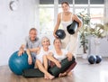 Group of people of different ages posing with pilates equipment