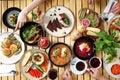 Group of people dining concept. Colorful, healthy food on a wooden table. Eating a lunch together, top view. Royalty Free Stock Photo